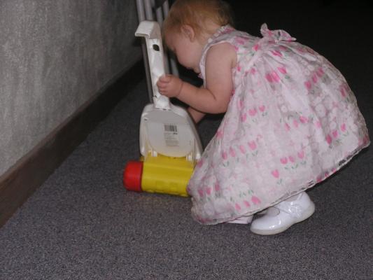 Sarah dressed up and playing with a toy sweeper