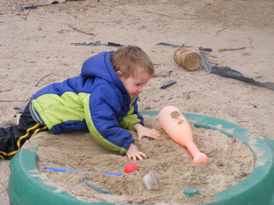 Noah plays in Grandma's sandbox