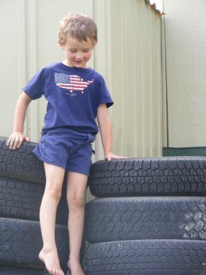 Noah plays on tires.
