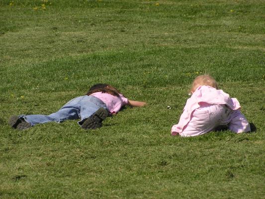 Andrea and Sarah crawl through the grass.