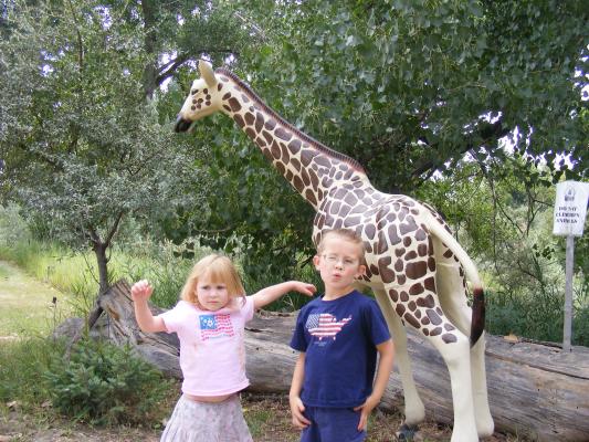Sarah and Noah by a giraffe sculpture.