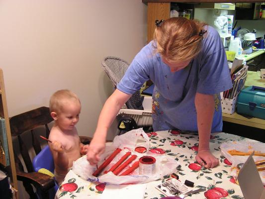 Katie and Noah paint some red sticks.