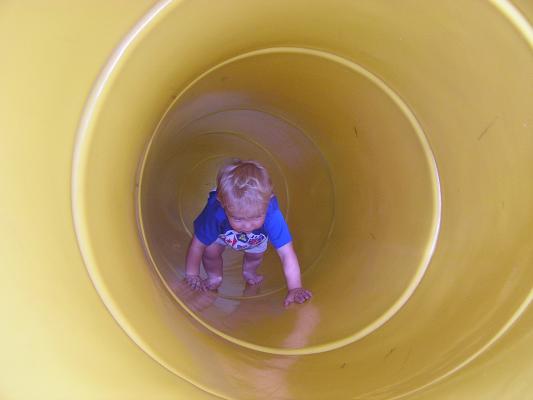 Noah goes back up the tube slide.