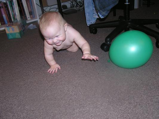 Sarah plays with a green baloon.