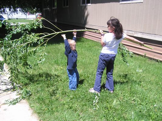 Malia and Noah play with a branch