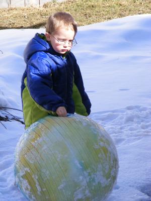 Noah with a big ball in the  snow.