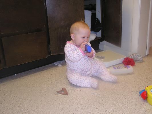Sarah plays on the bathroom floor.