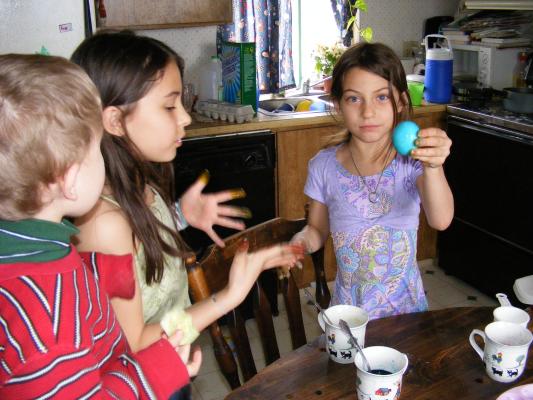 Noah, Malia and Andrea dye eggs.