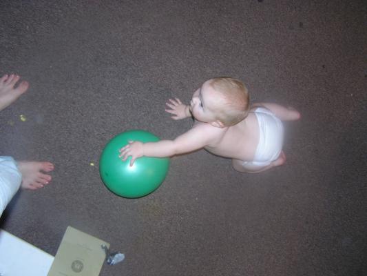 Sarah plays with a green baloon.
