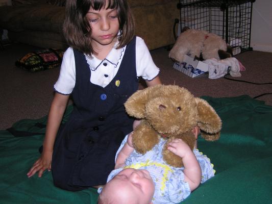Andrea helps Sarah play with a stuffed puppy.