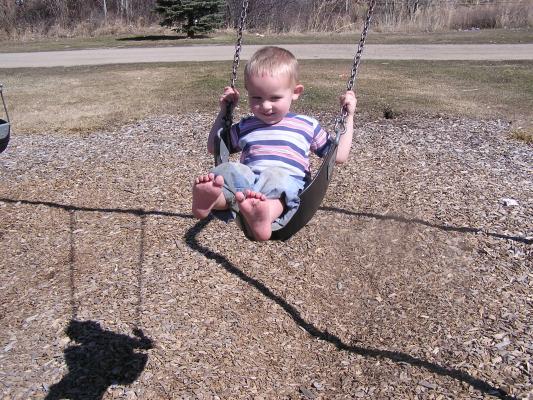 Noah plays on the swings.