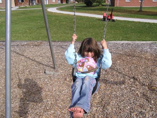 Andrea is swinging at the park.