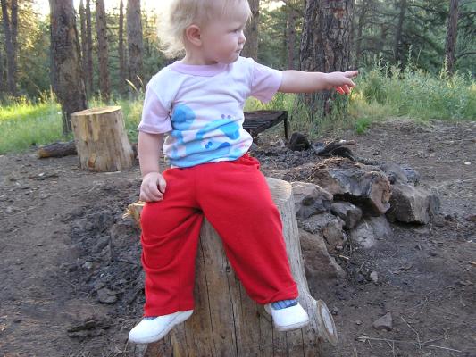 Sarah on a stump in her jammies