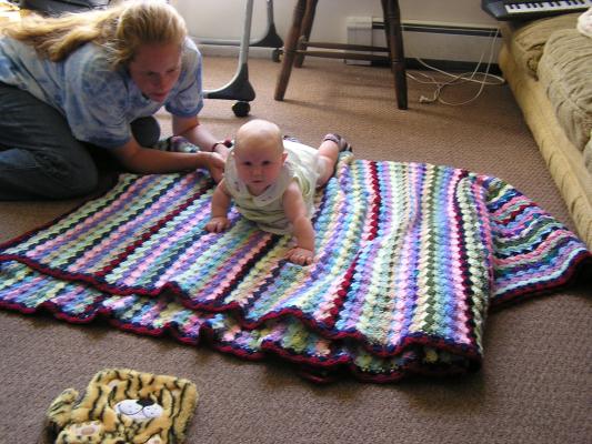 Sarah works on crawling on a blanket.