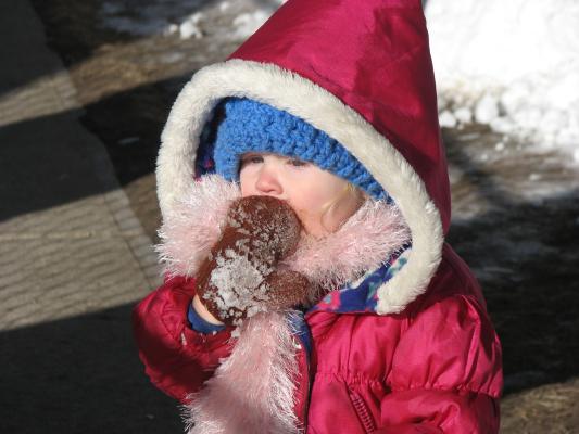 Sarah licks snow off her brown mitten