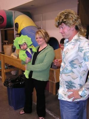 Baby Ashton as a dinosour with mom Terra and Chris as a retro man.