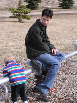 Mike and Noah play with the teetertotter.