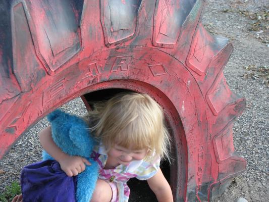 Sarah plays in the red tire at the park in the Covered Wagon trailer court.