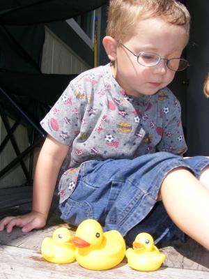 Noah plays with ducks on the porch.
