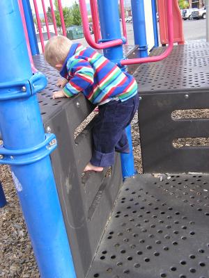 Noah climbs at the playground.