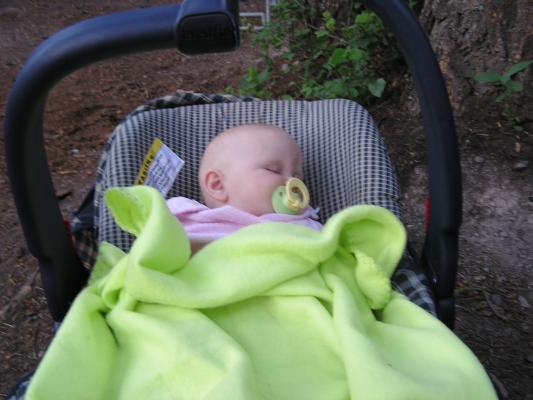 Sarah sleeps in her car seat with a color coordinated blanket an pacifier.
