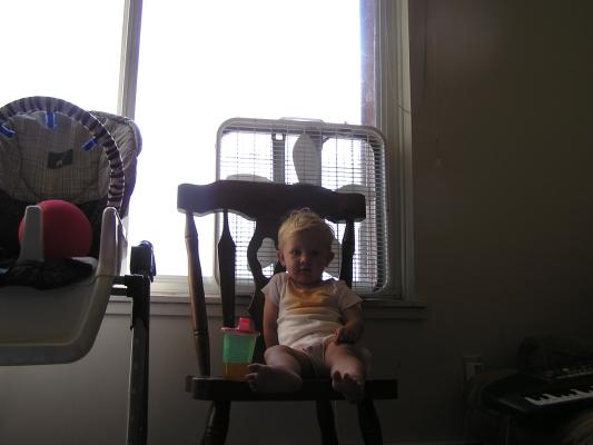 Noah sits on a chair with some orange soda.