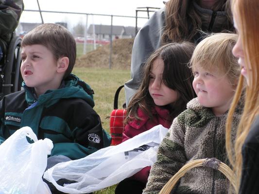 Kids listen to the story of Easter after the Easter egg hunt.