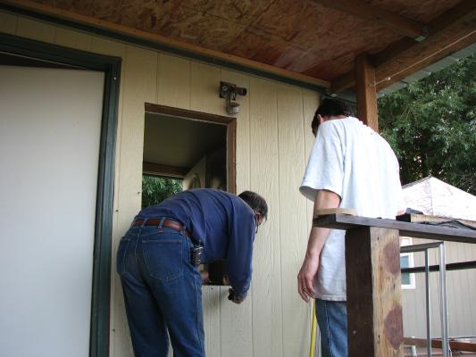 Robert and David working on a window. Will it make the porch warmer?