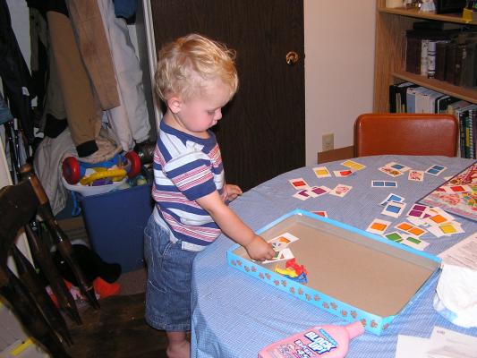 Noah plays with the Candyland pieces.