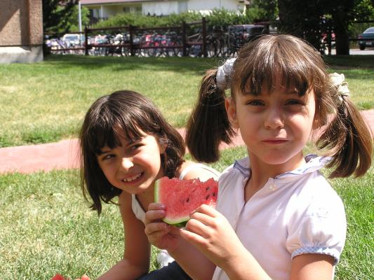 Malia and Andrea eat watermelon.
