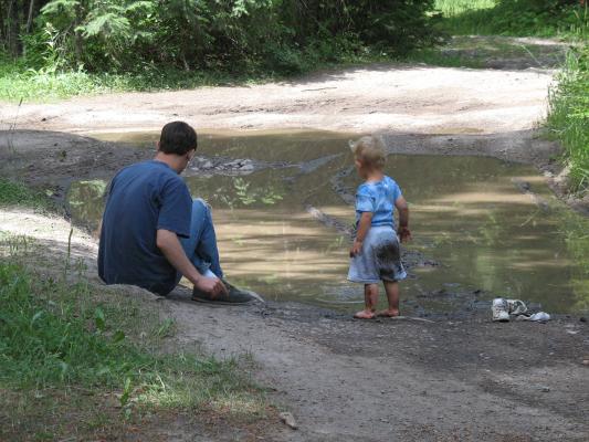 David and Noah play in a mud puddle.