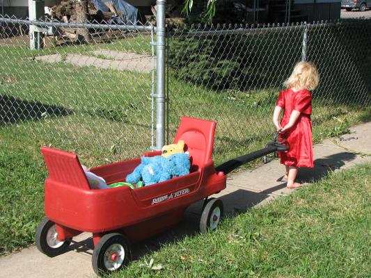 Sarah pulls the wagon in her red dress.