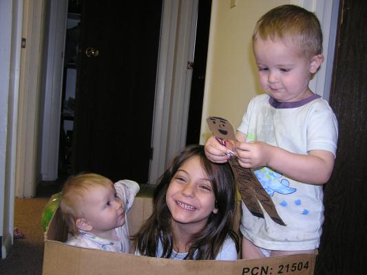 Sarah, Andrea and Noah play in a box.