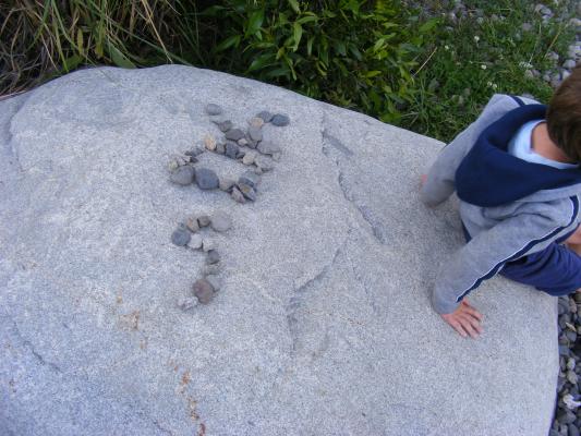 Noah writing his name in rocks.
