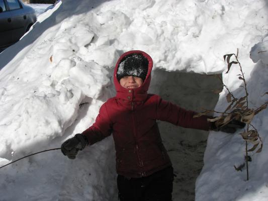 Andrea decorates the snow fort with sticks