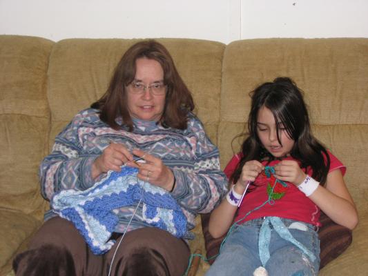 Bea is teaching Malia to crochet
