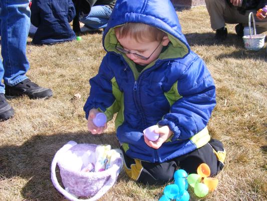 Noah examines the spoils of the GVCC Easter egg hunt.