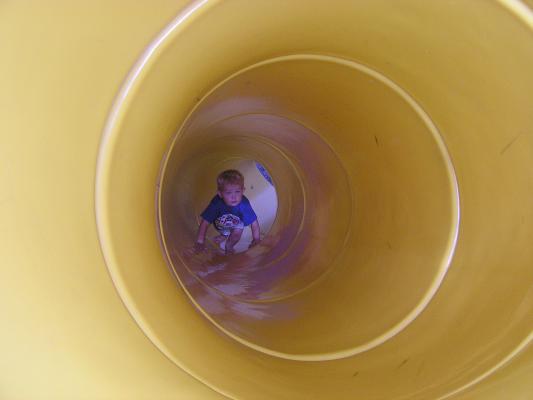 Noah goes back up the tube slide.