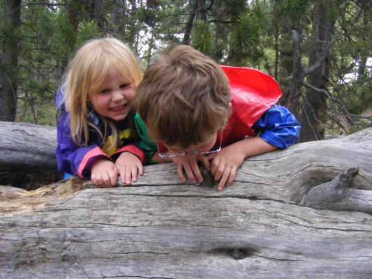 Sarah and Noah play bear on a log