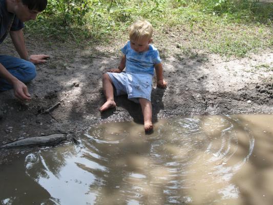 David and Noah play in a mud puddle.