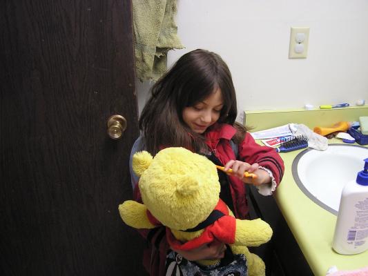 Pooh bear gets his teeth brushed.