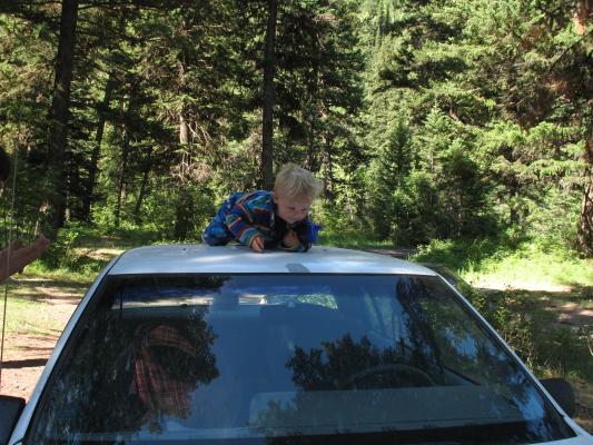 Noah climbing on the car.
