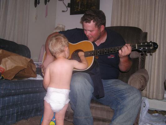 Titus teaches Noah how to play the guitar.