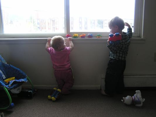 Sarah and Noah play cars on the window sill.