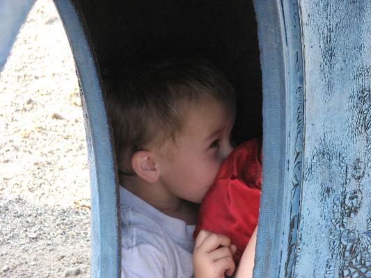 Noah plays in the blue tire at the park in the Covered Wagon trailer court.