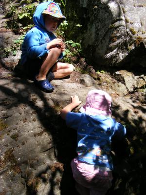 Noah and Sarah climb on rocks.