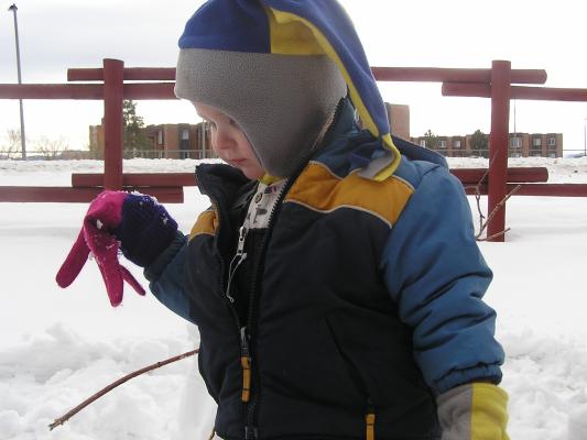 Noah is working on a snowman. 
He likes to wear my pink and purple gloves.
