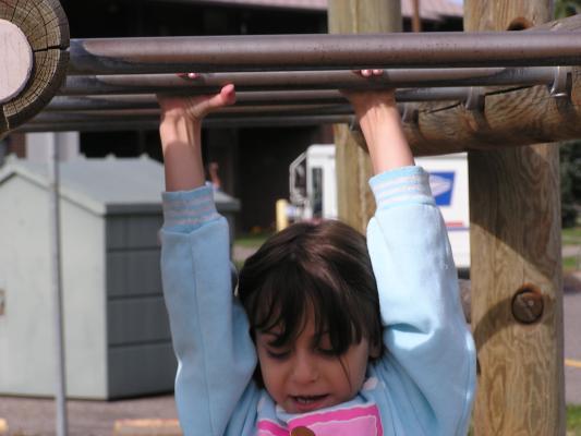 Andrea is going across the monkey bars again.