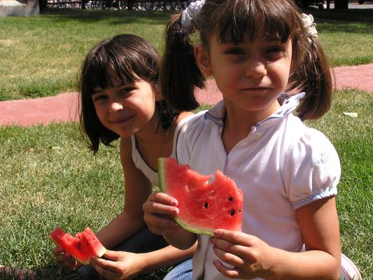 Malia and Andrea eat watermelon.