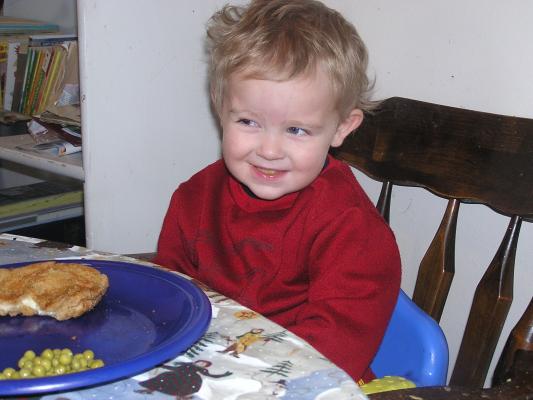 Noah likes to show off his teeth too. He is eating grilled cheese and peas.